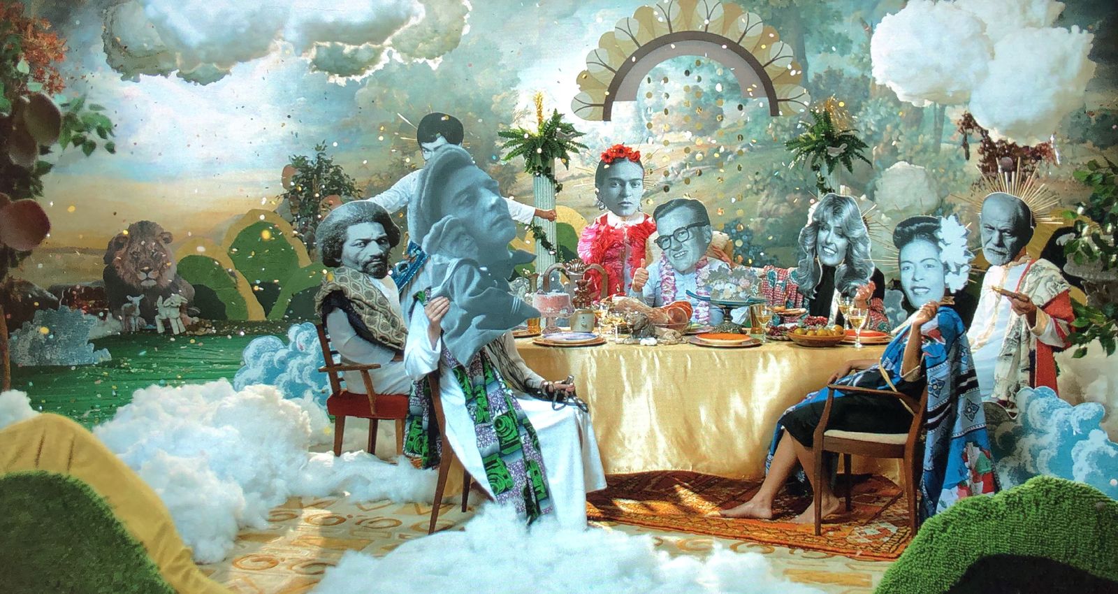 Still from Dick Johnson Is Dead: a banquet in heaven, guests around a crowded table under a sunburst arch, with clouds, hills and a painted sky behind.
